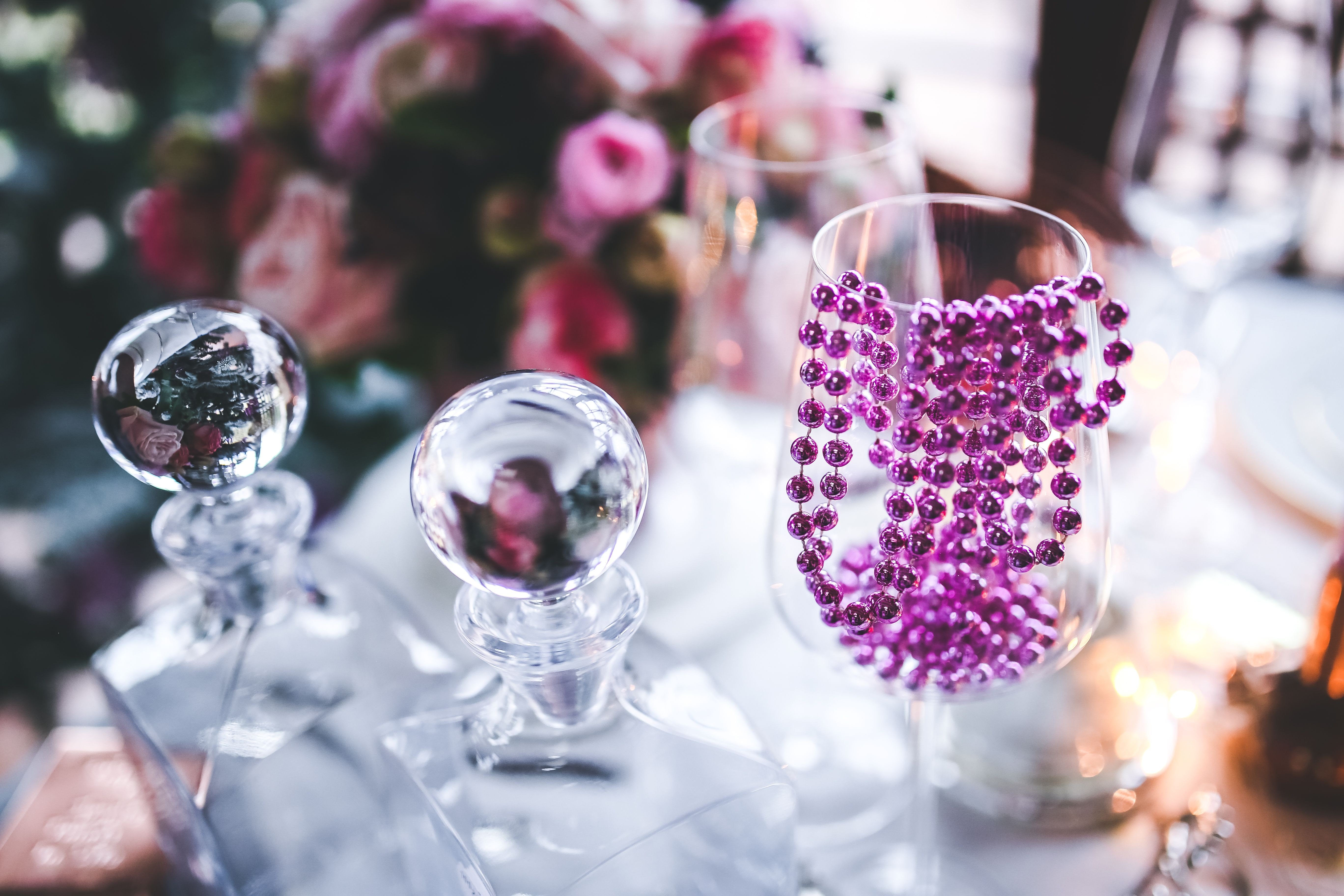 A sophisticated table setting with crystal glassware and purple beads, perfect for celebrations.