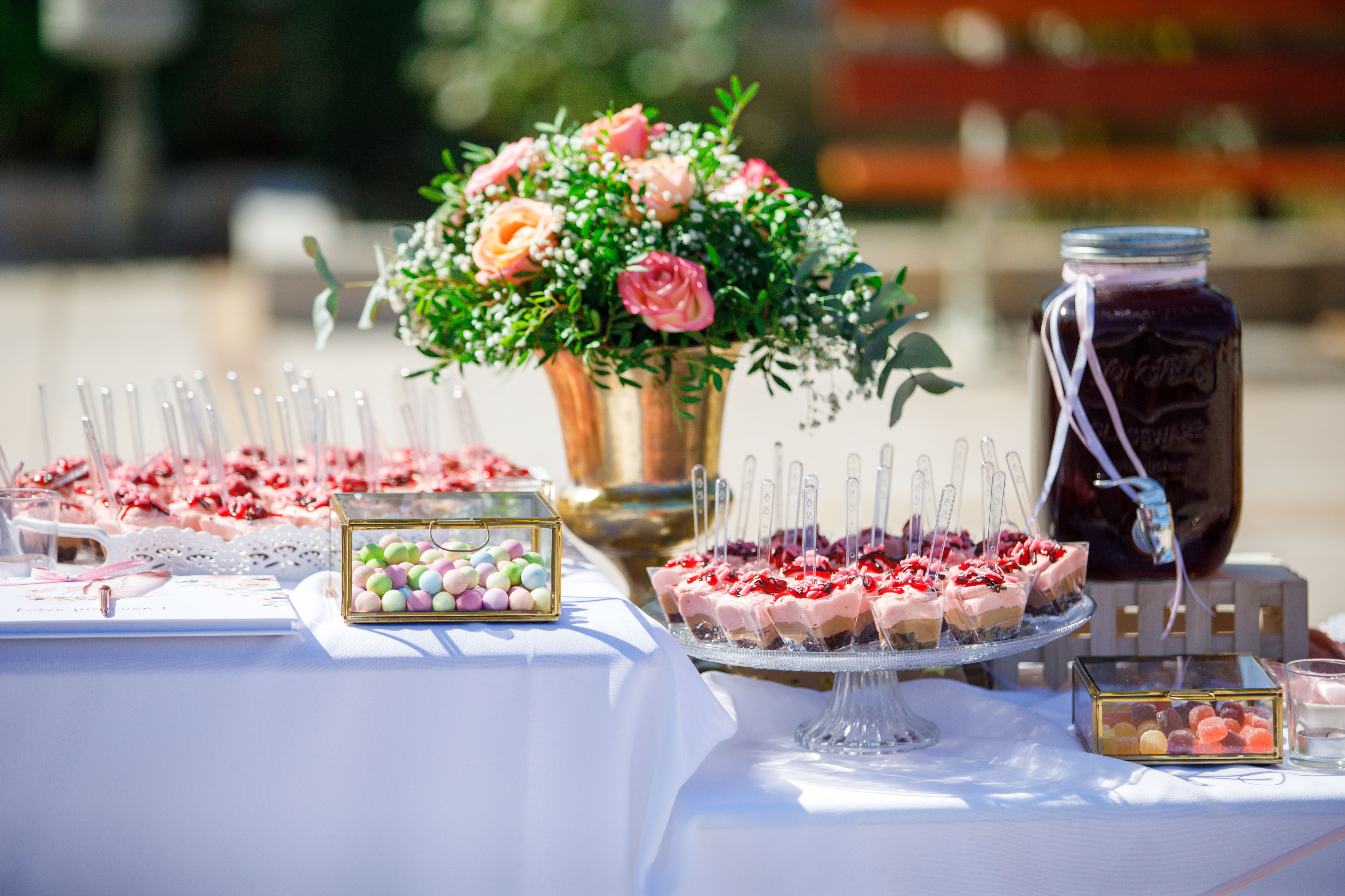 Elegant dessert buffet setup with floral centerpiece, perfect for weddings or events.