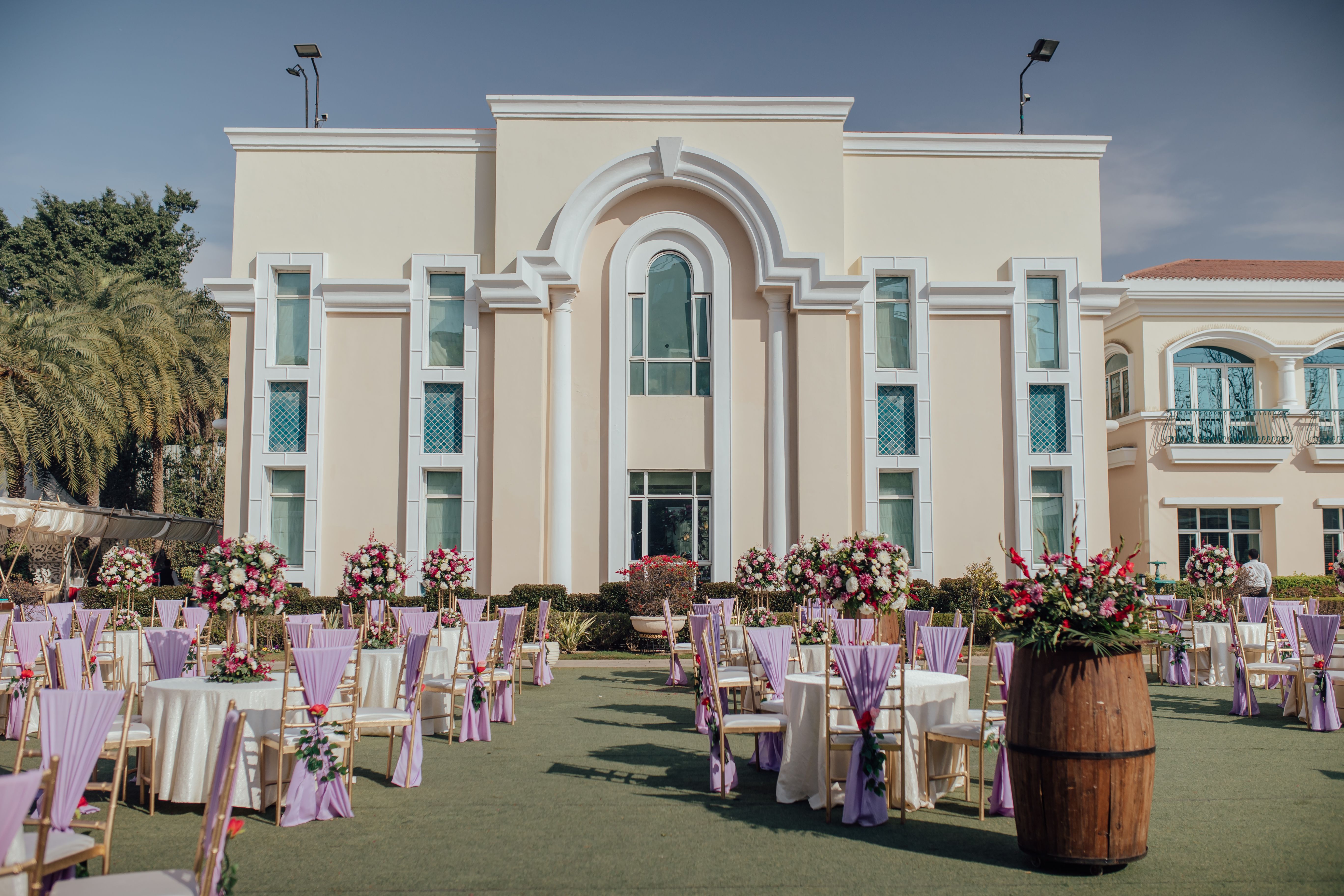 Charming outdoor event setup with floral arrangements and elegant decor at a sunny venue.
