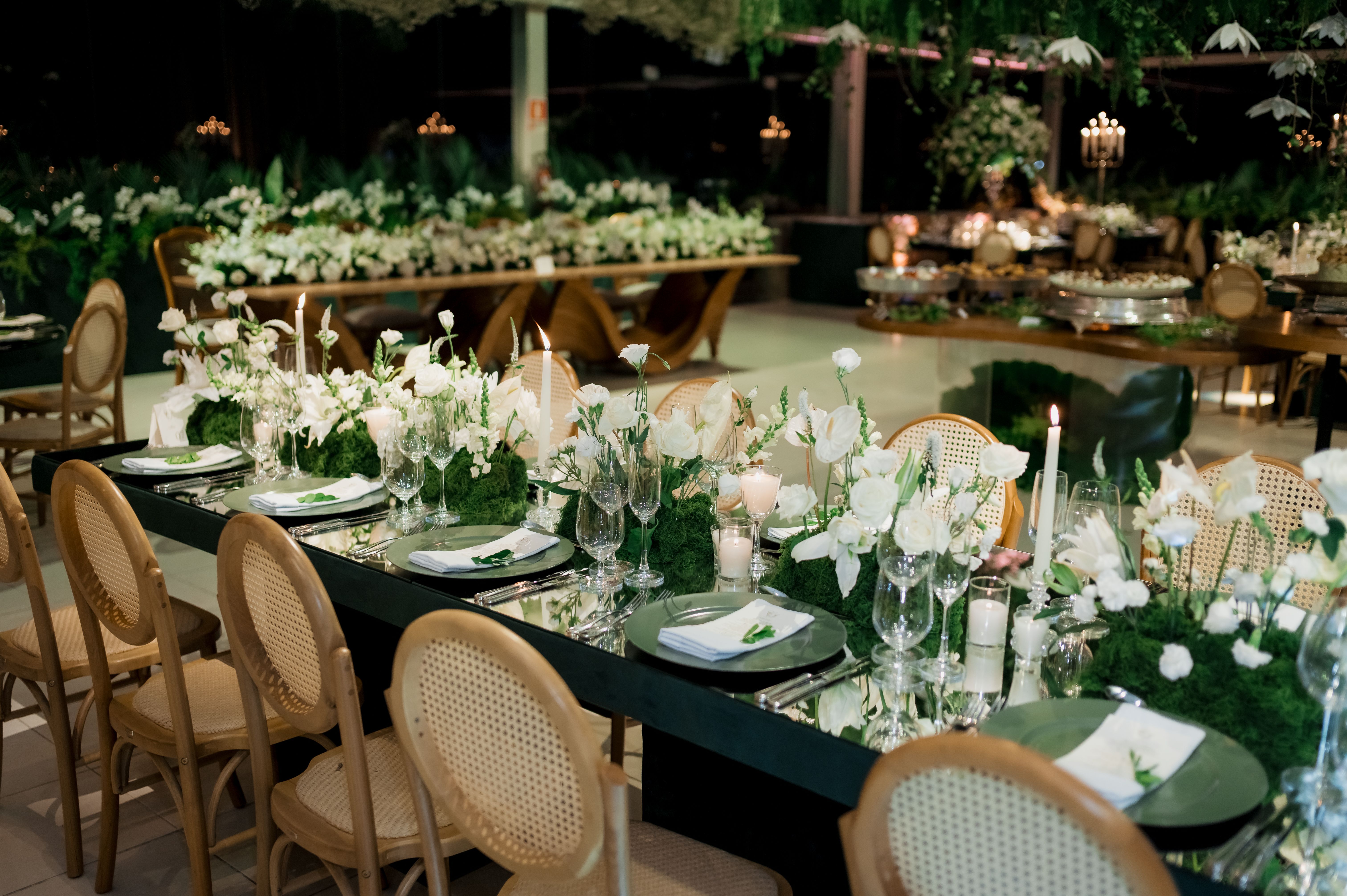 Luxurious wedding reception with elegant table setting, white flowers, and candles.