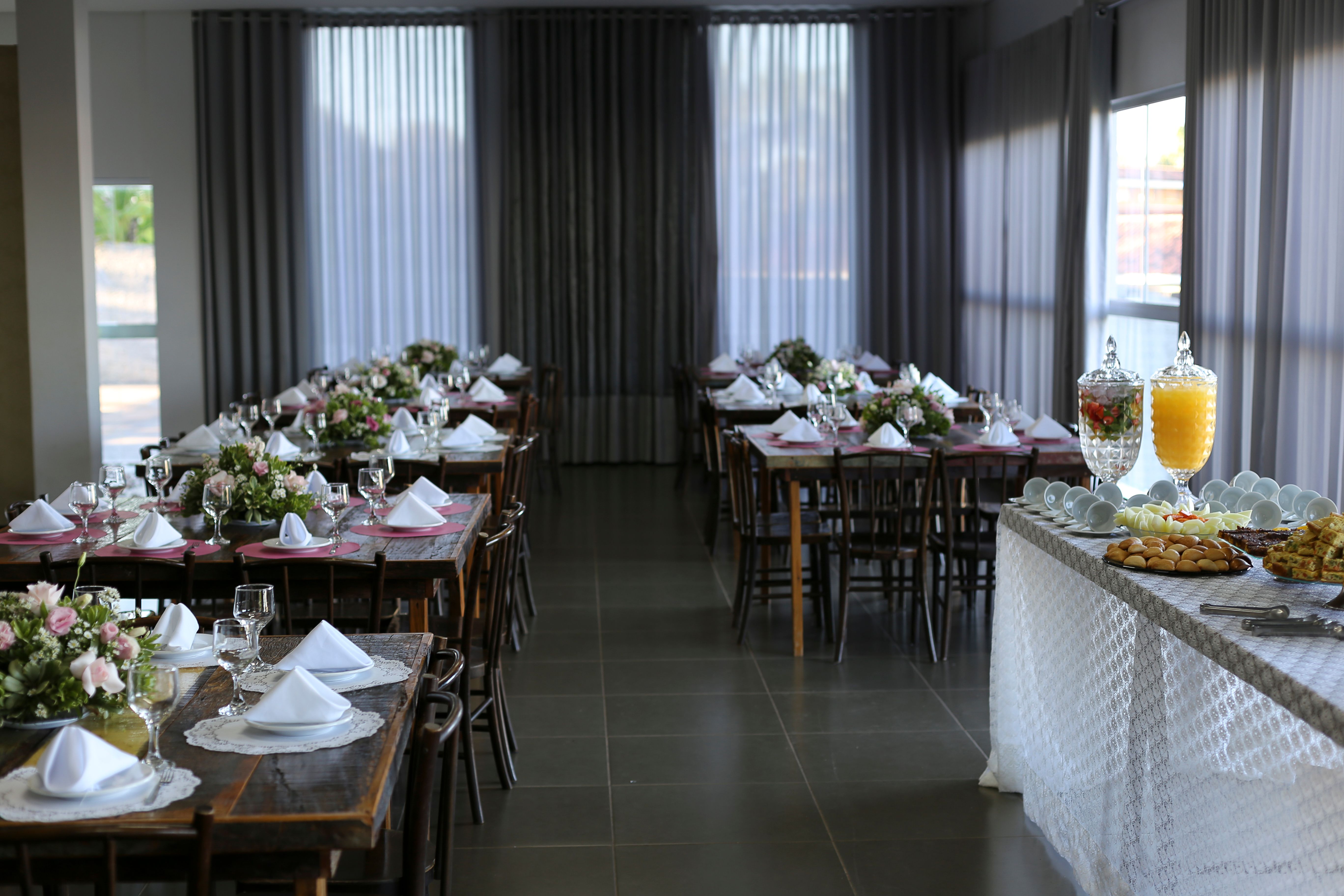 A beautifully arranged dining room with tables set for an event and a buffet table with refreshments.