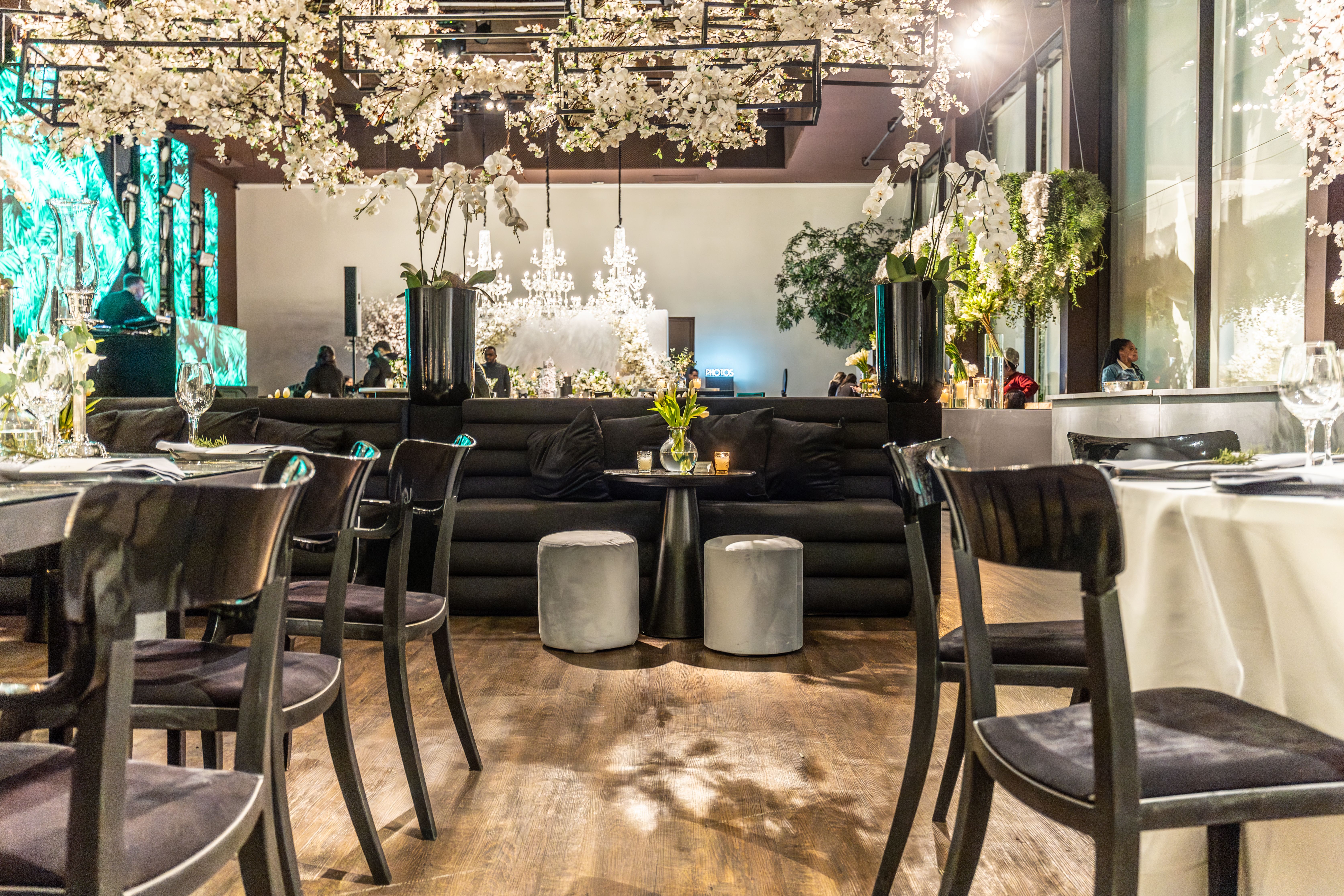 A beautifully decorated wedding venue featuring chandeliers and abundant floral arrangements.
