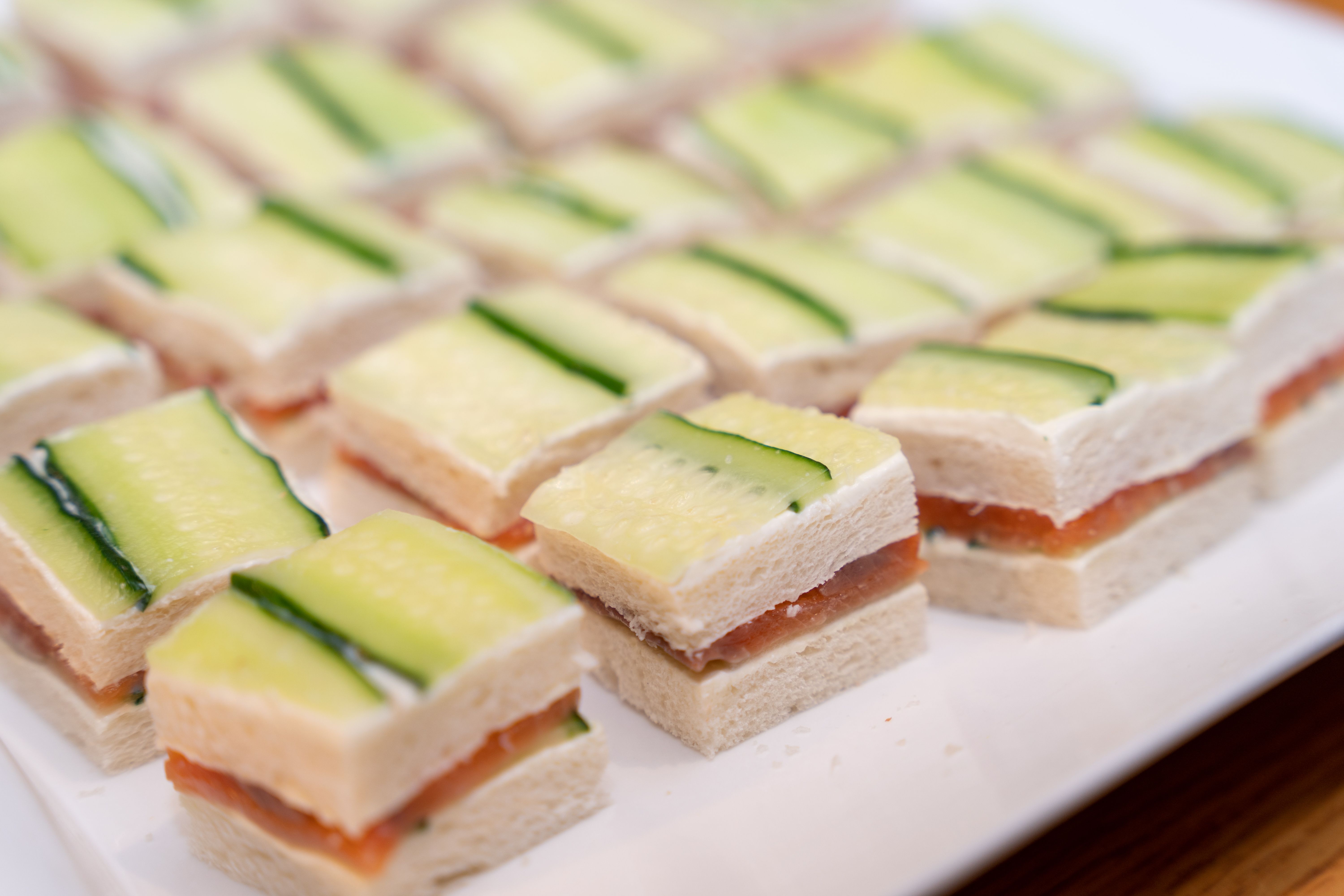 Close-up of elegant cucumber and salmon tea sandwiches perfect for parties.