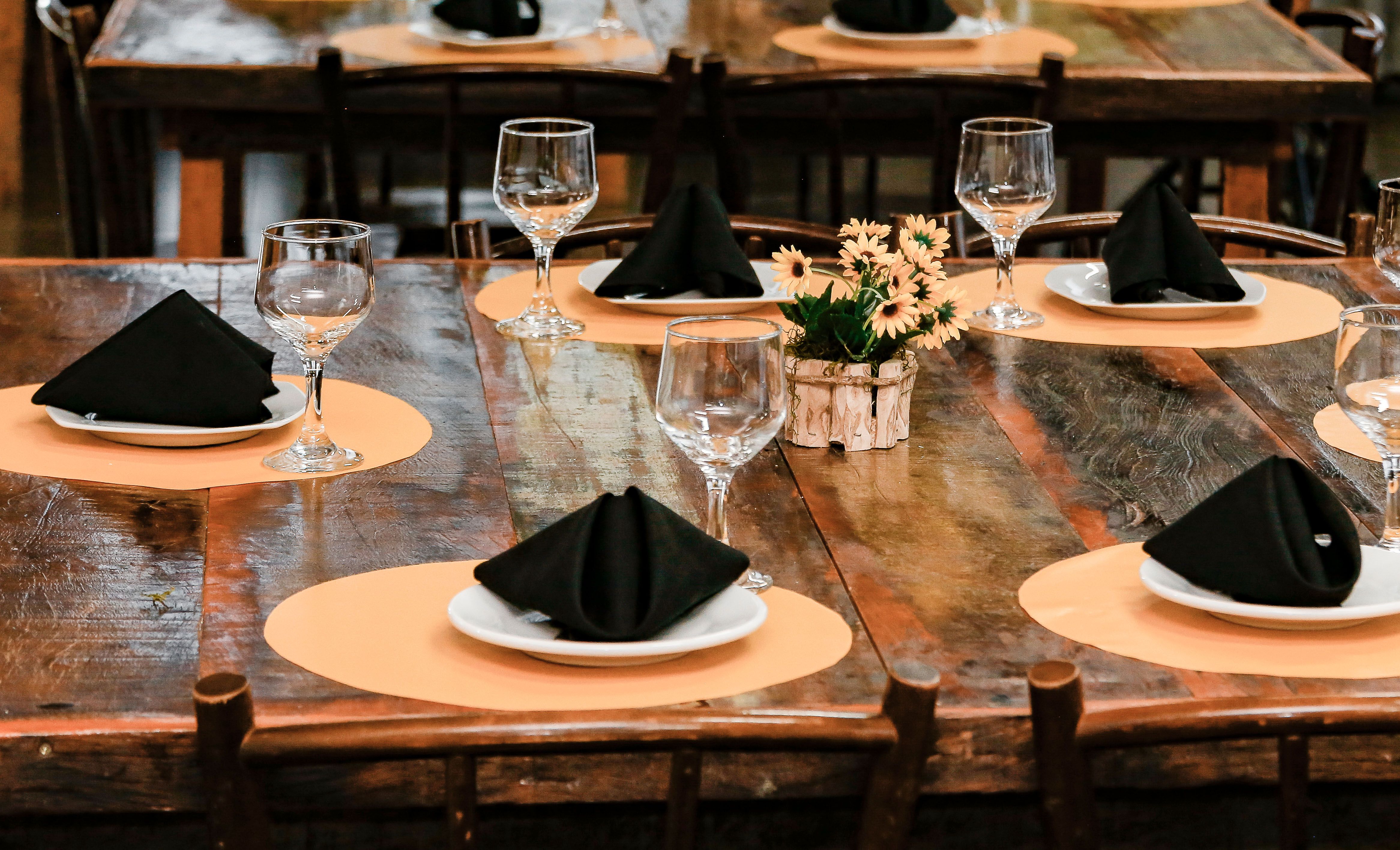 Charming rustic table setting with black napkins and flowers, perfect for events.