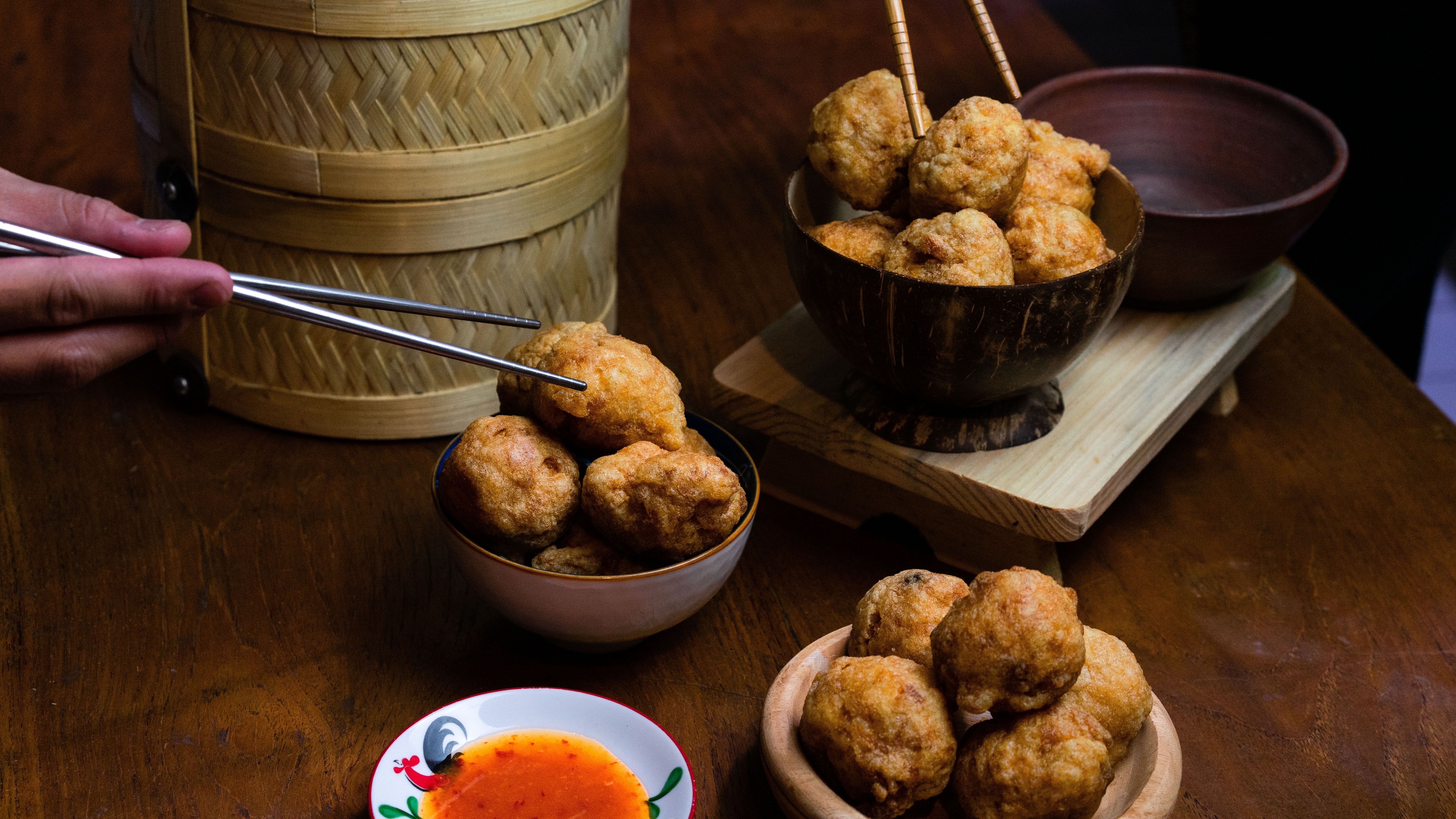 Delicious Indonesian fried snacks served with a side of chili sauce and chopsticks.