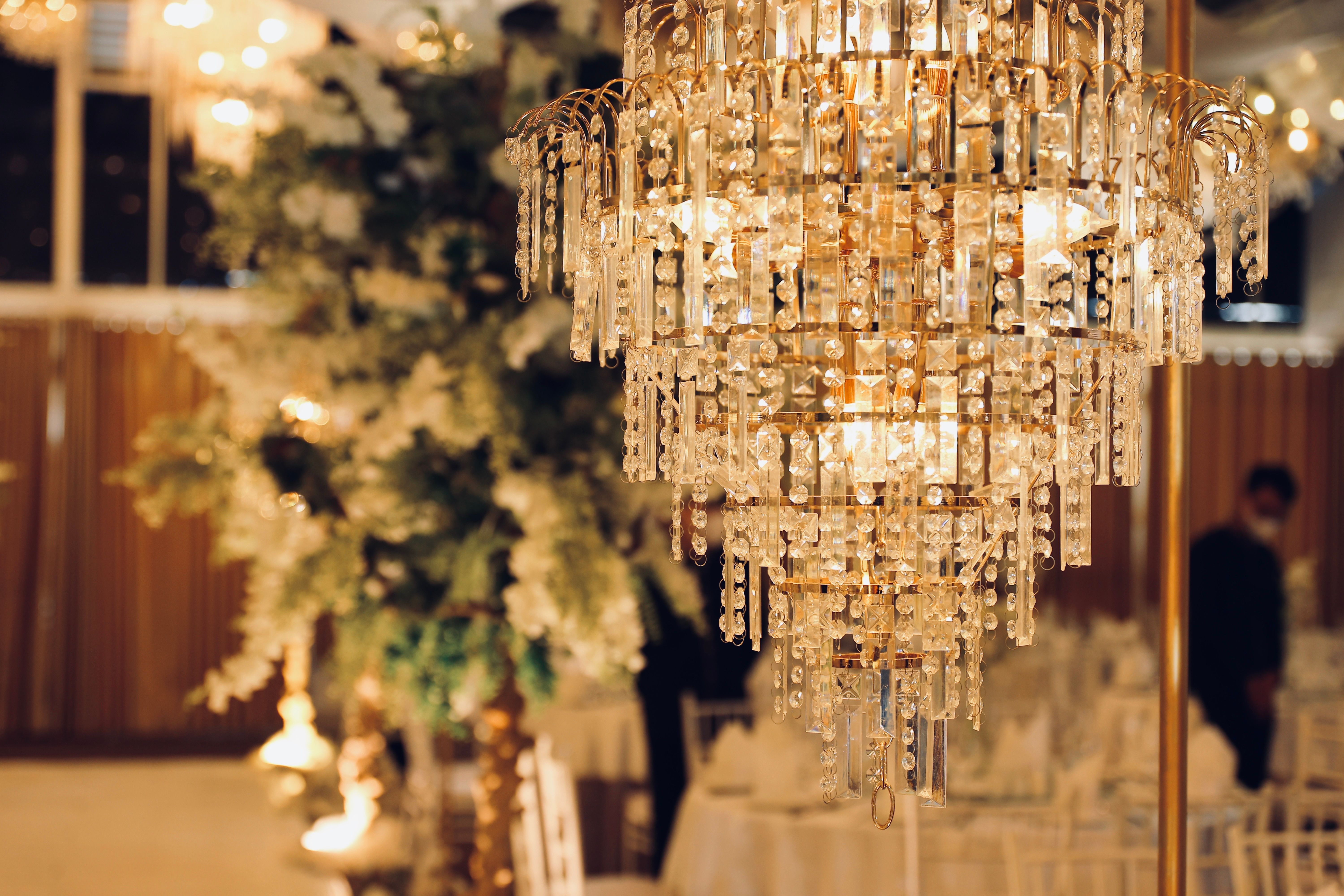 Luxurious crystal chandelier illuminating an elegant indoor event setting.