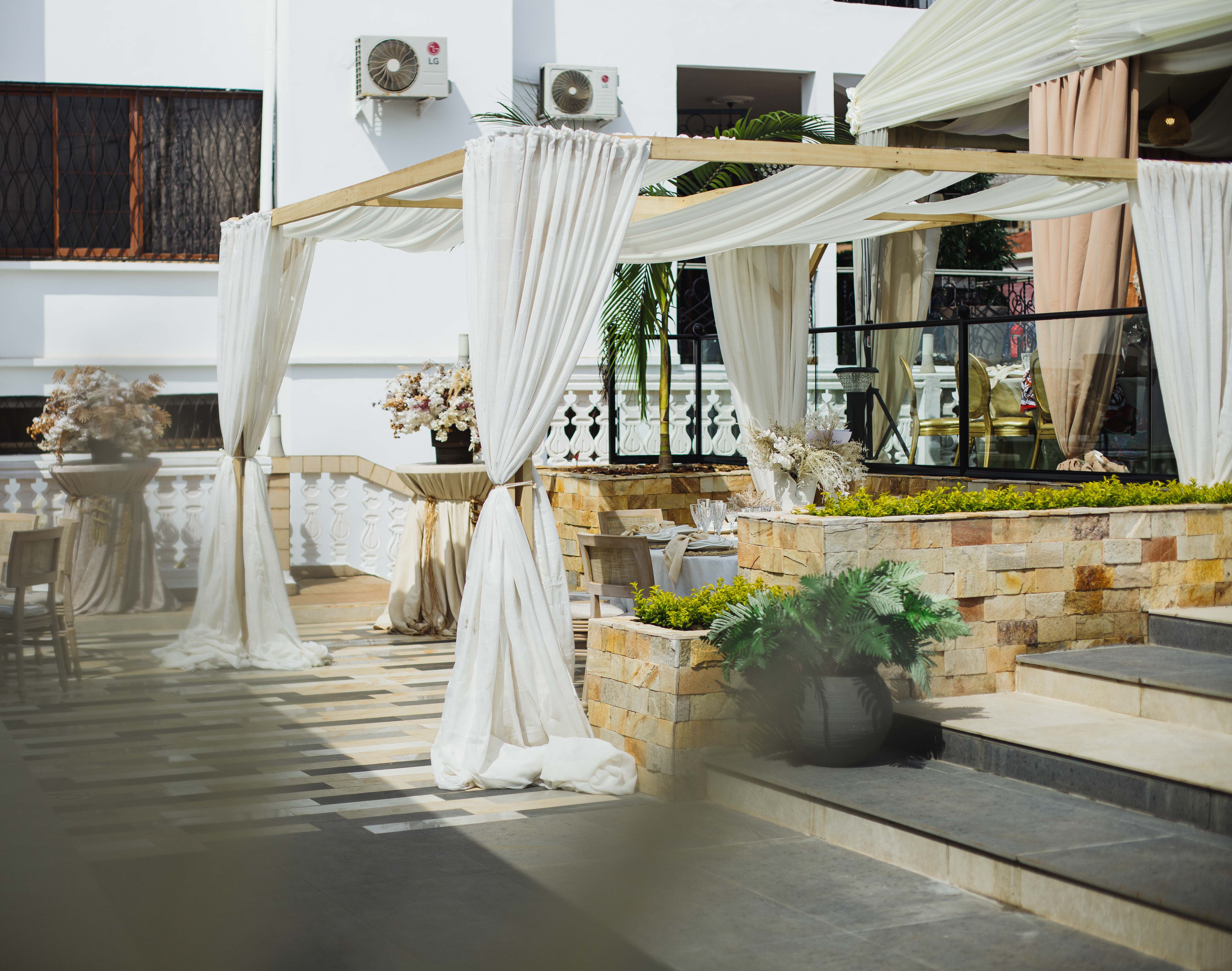 Elegant outdoor venue with draped canopies and decorative plants, ideal for events.