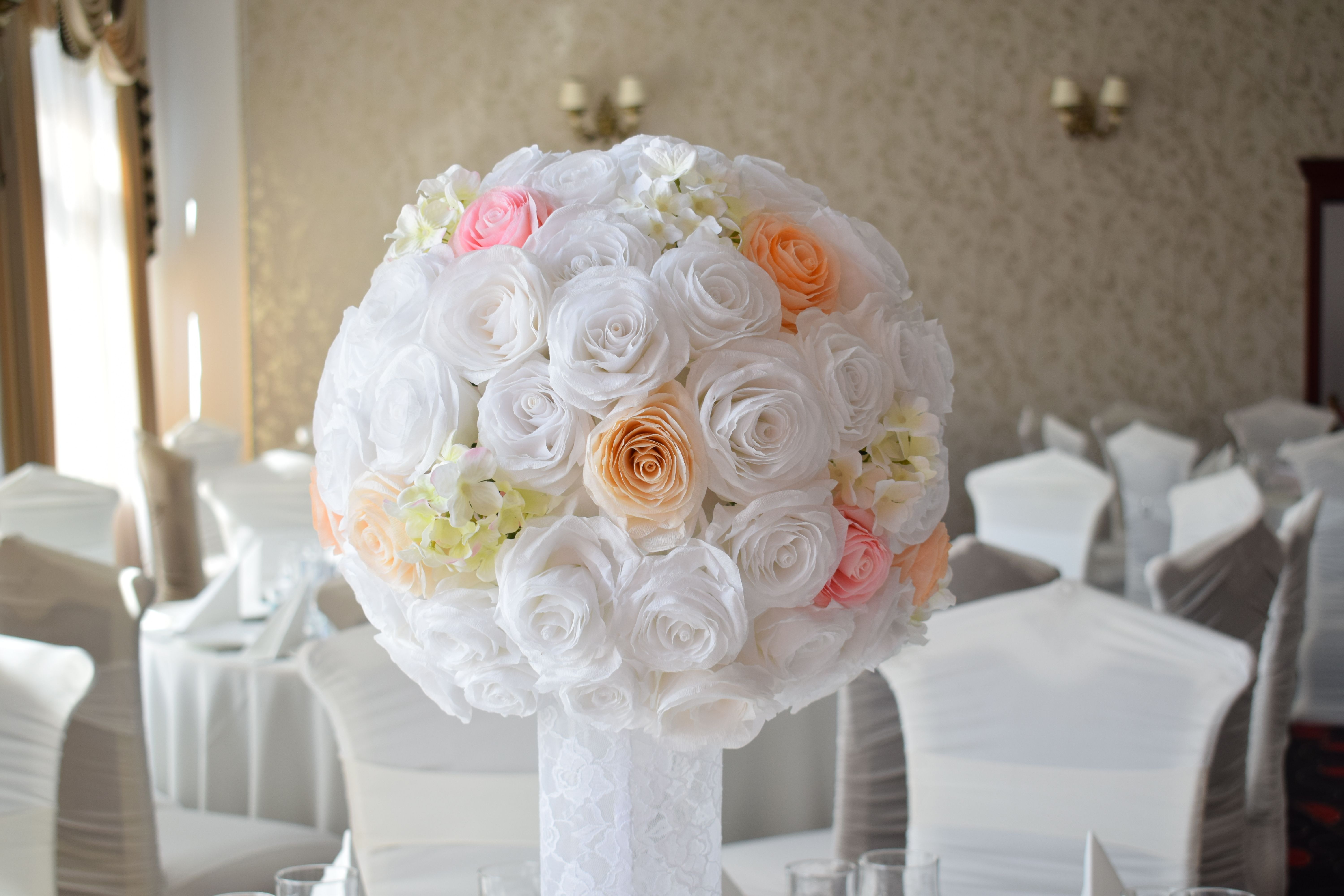 Beautiful rose and hydrangea floral centerpiece at a wedding reception, creating an elegant setting indoors.