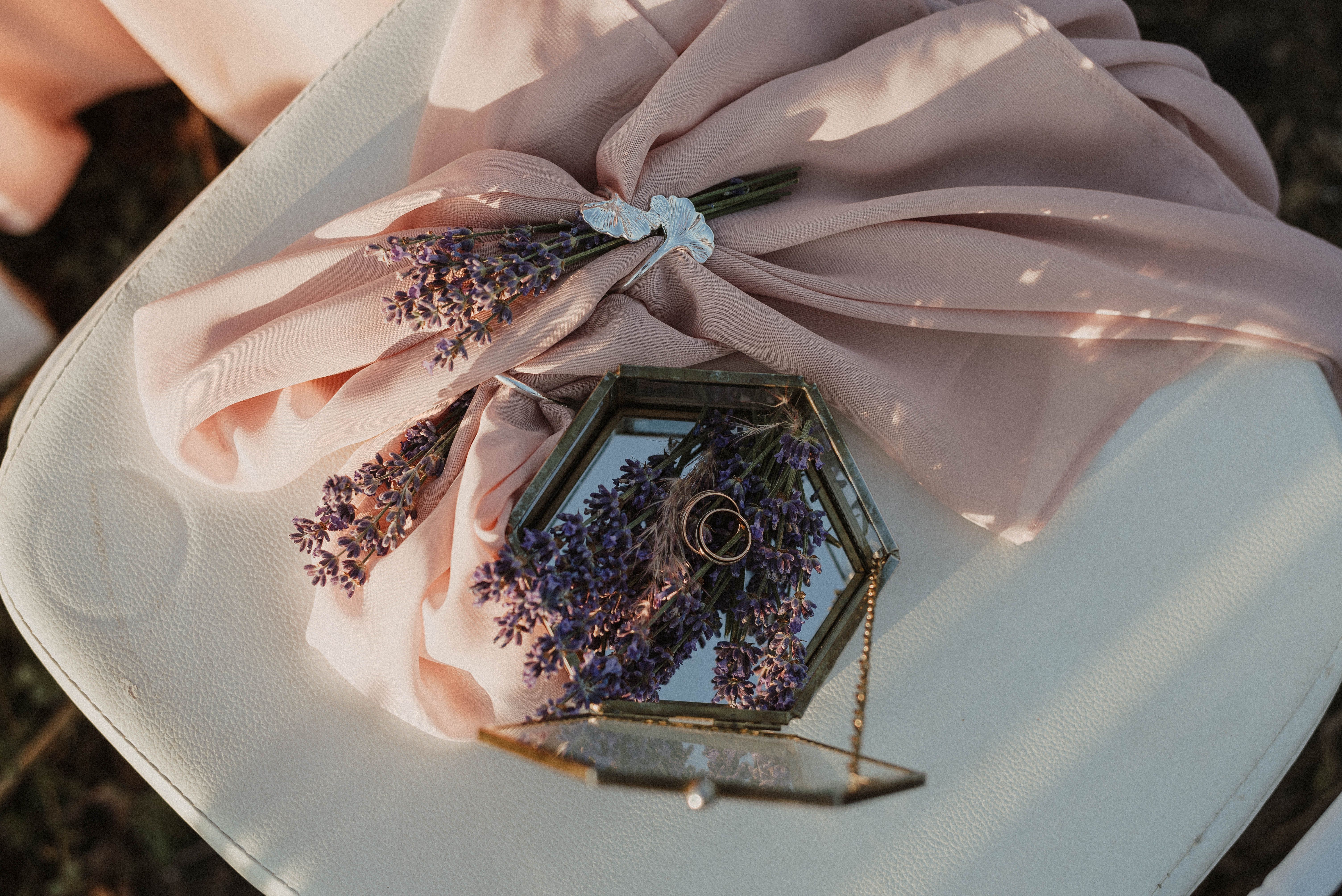 Elegant display of wedding rings on lavender and pink fabric, perfect for romantic occasions.