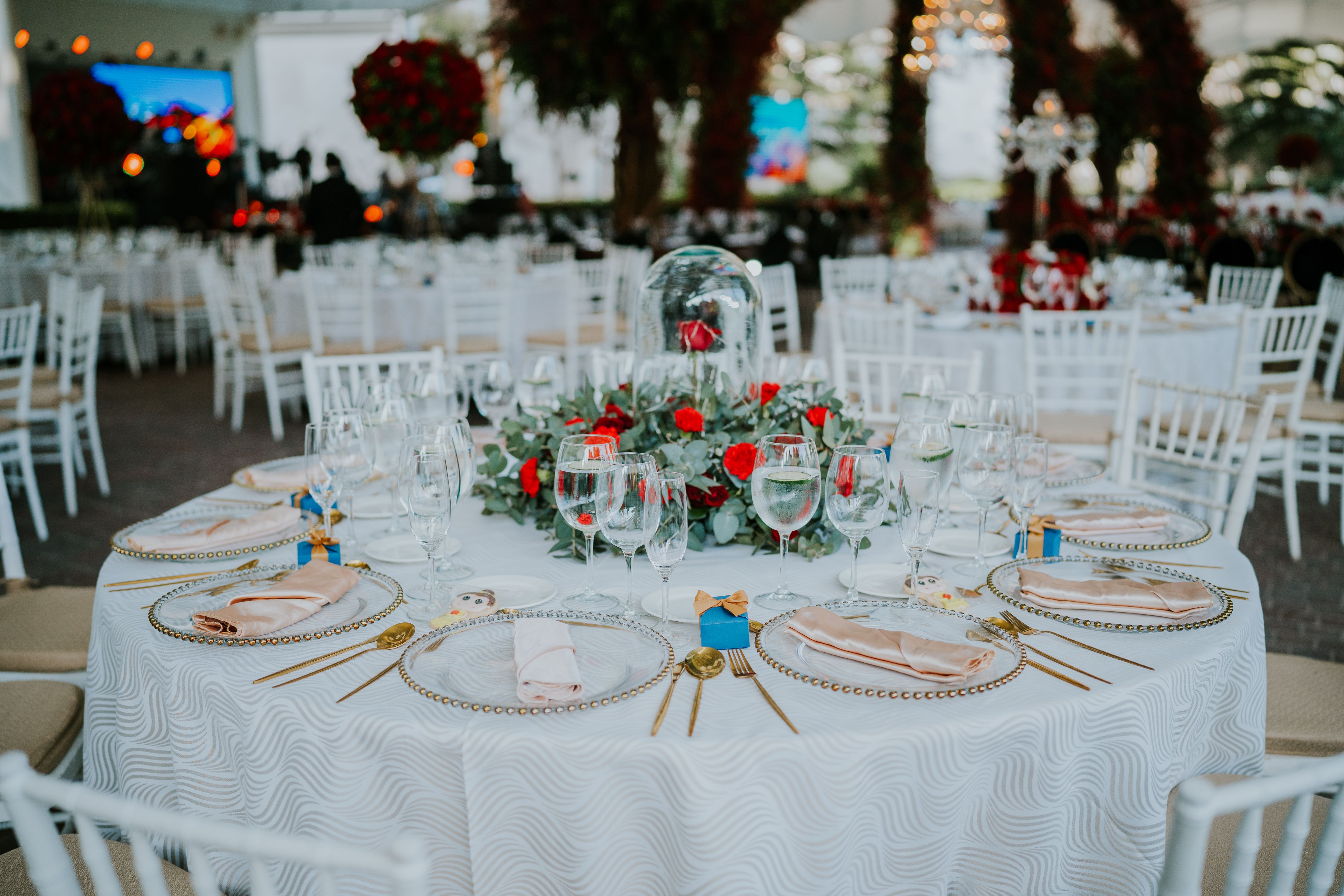 Beautifully decorated wedding round table with floral centerpiece and elegant tableware, perfect for celebrations.