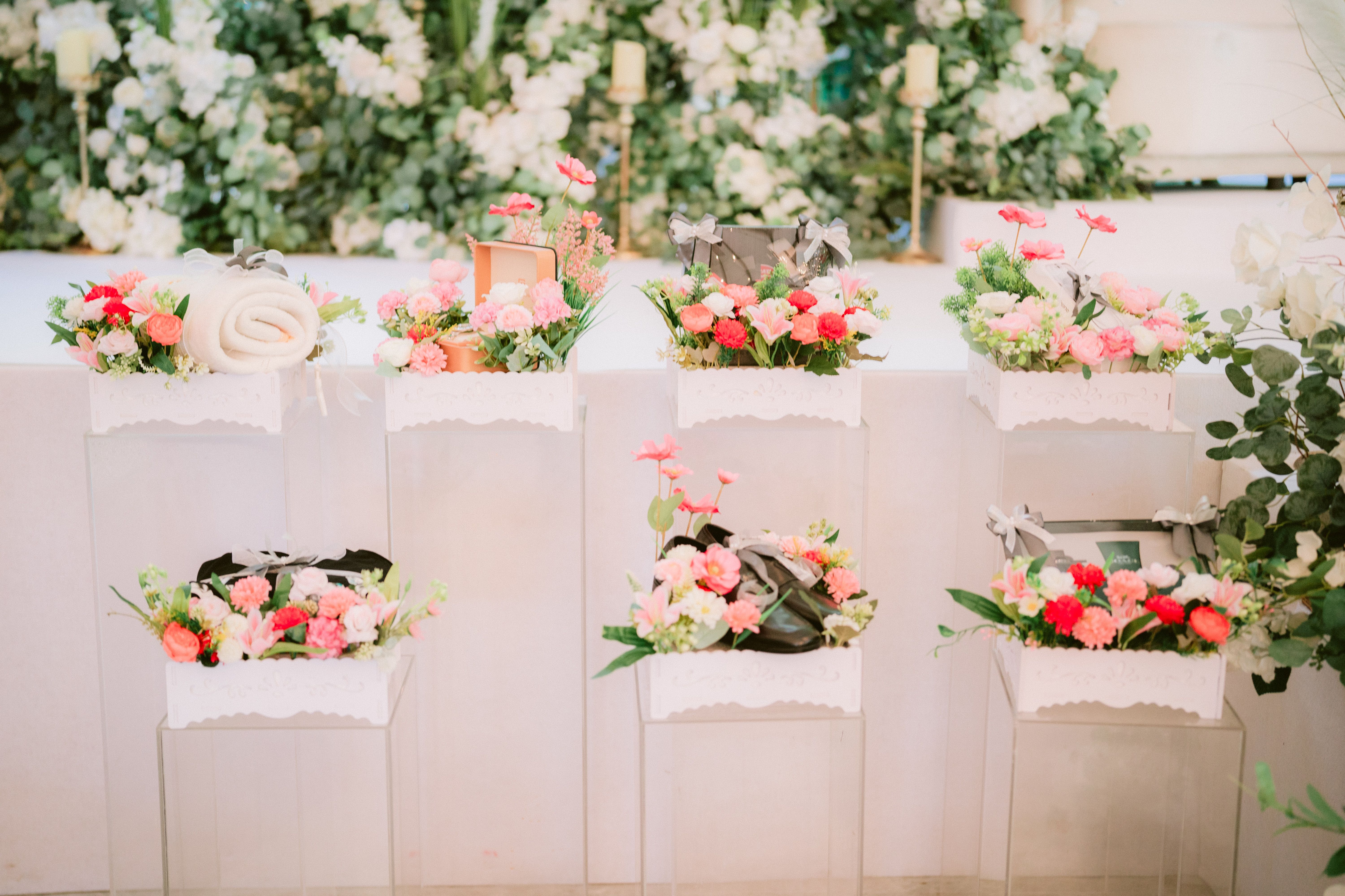 Vibrant floral arrangements with gift boxes in an elegant indoor setting.