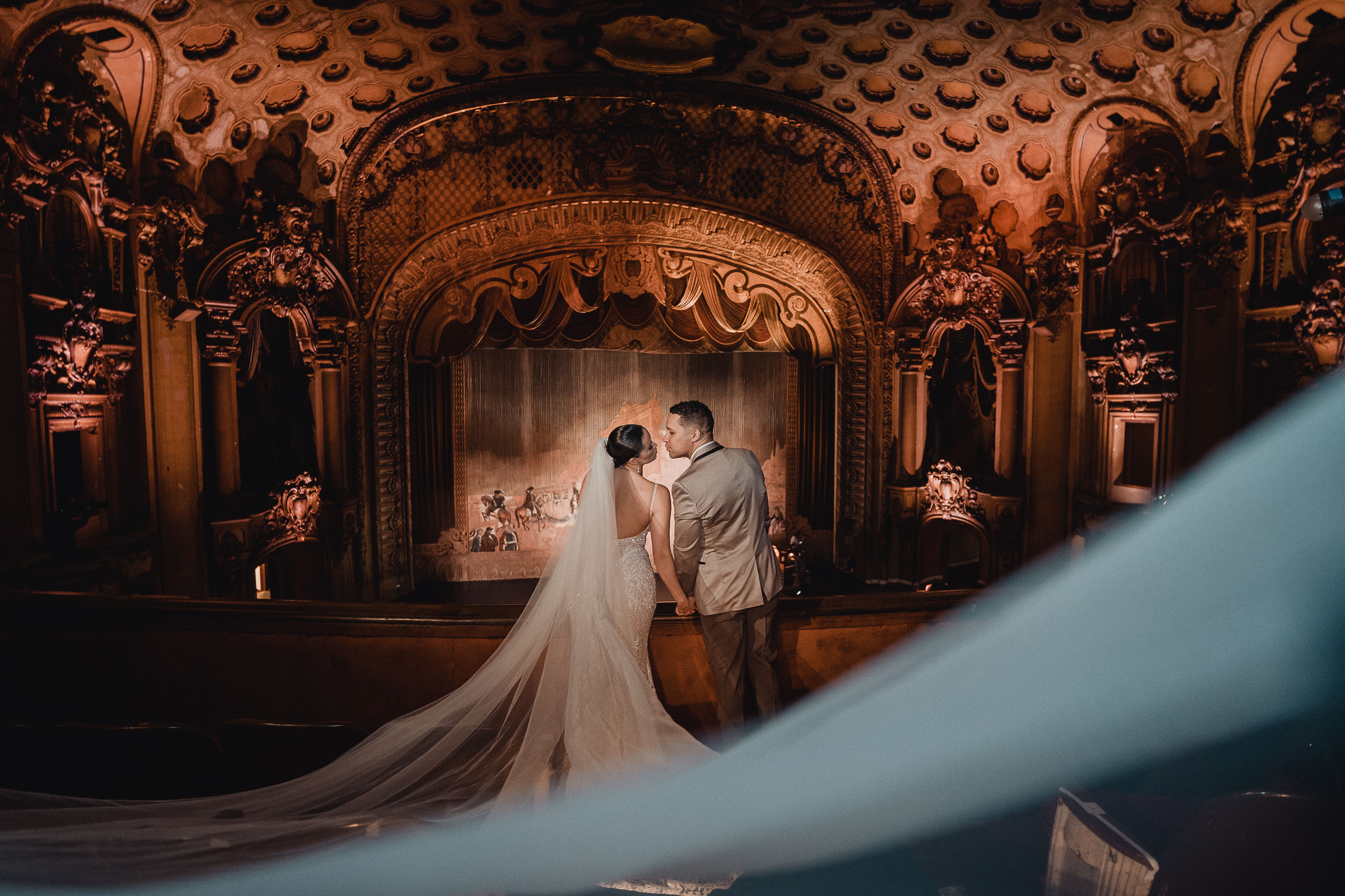 Couple kissing within the opulent interior of an historic Los Angeles theater, capturing wedding romance.