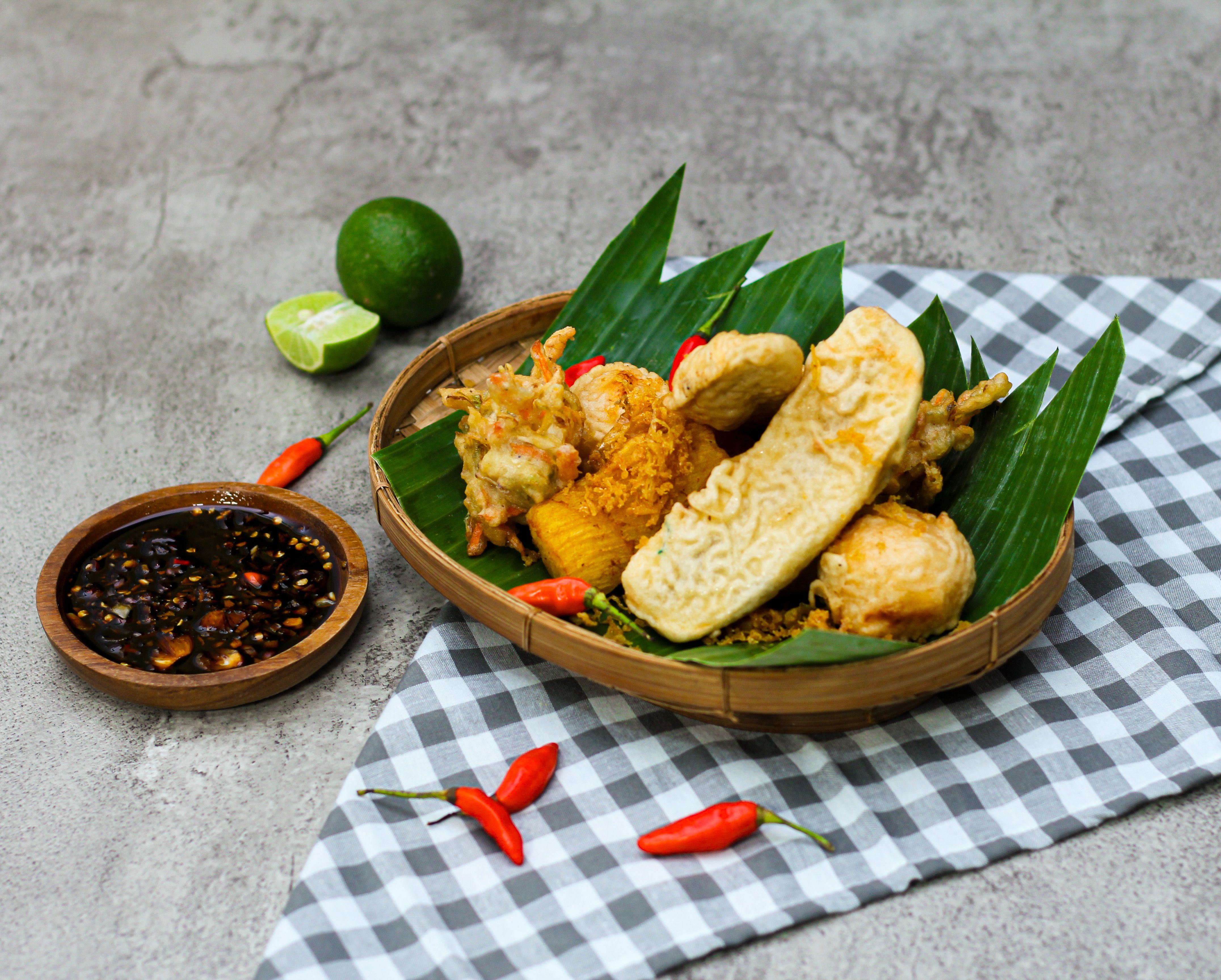 A traditional Indonesian meal served on banana leaves with spicy sambal and fresh lime.