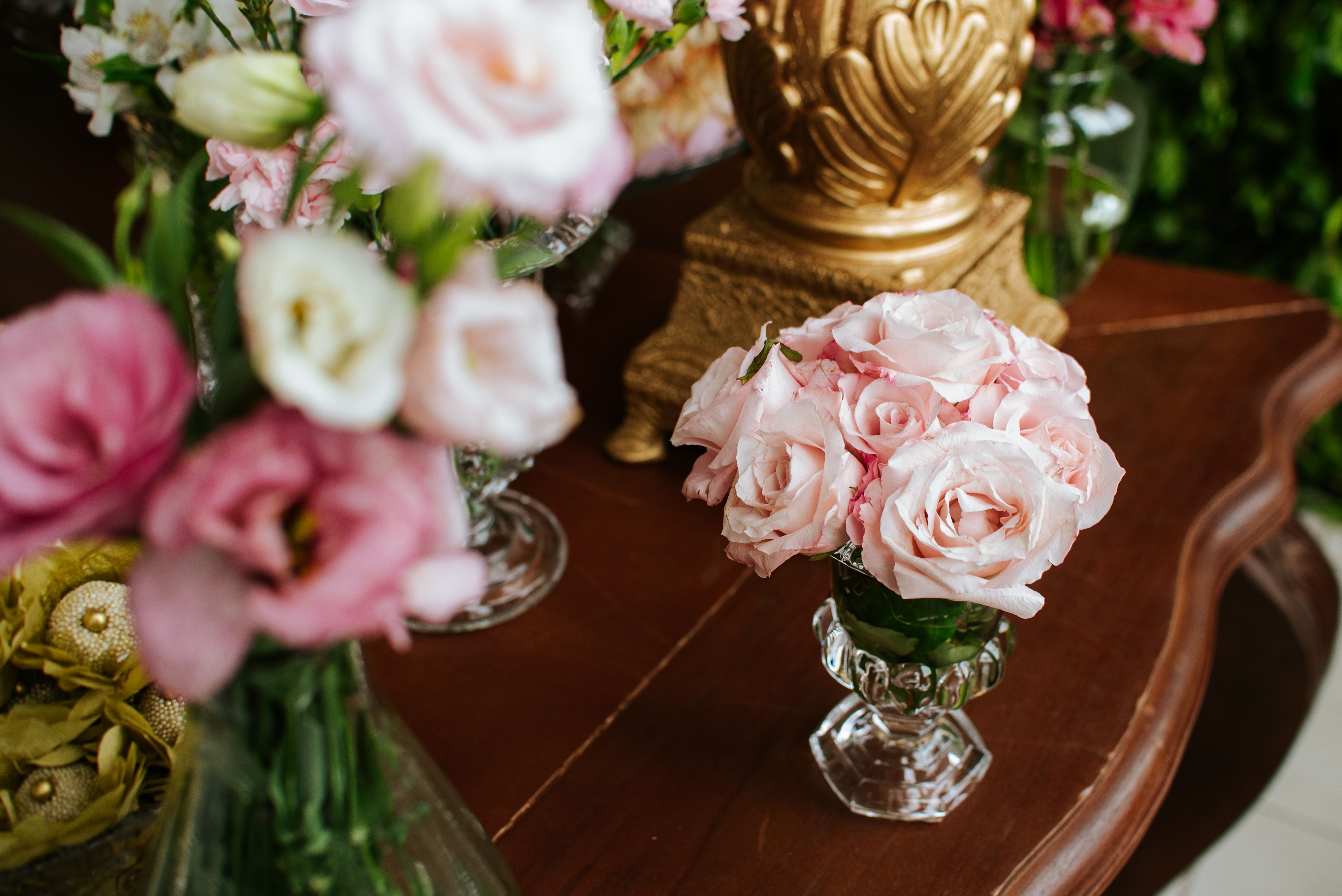 Charming floral arrangement with pink roses in a stylish crystal vase on a wooden table.